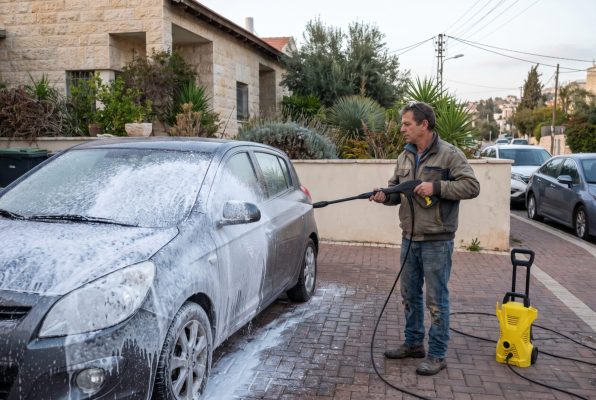 מכונת שטיפה לרכב עם שכבת קצף על רכב בחניה